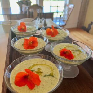 Cold cucumber gazpacho in glass cups with edible flowers