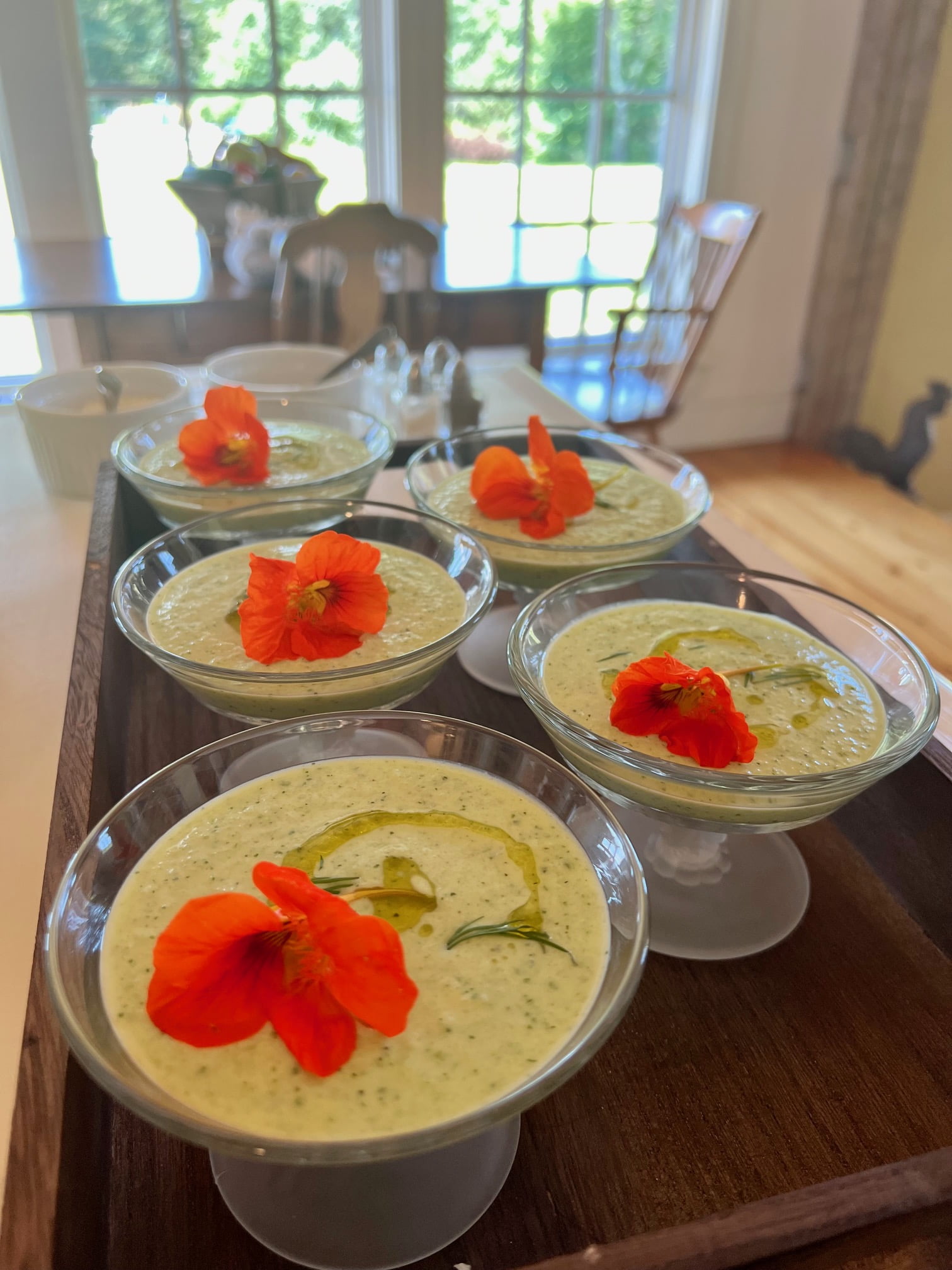 Cold cucumber gazpacho in glass cups with edible flowers